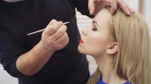 Makeup Artist Applying Makeup to Blonde Woman