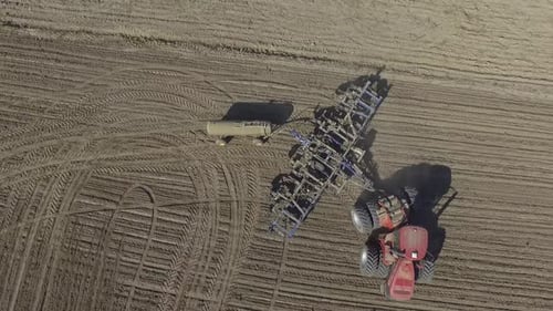 Big red combine working on the field cultivating and applying nitrogen ASP