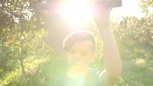 Child Hanging on Bar in Sunny Rural Setting