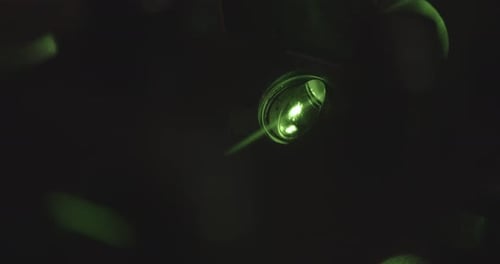 Green neon light projector with light flashing in dark room,close up shot. Party in night club.