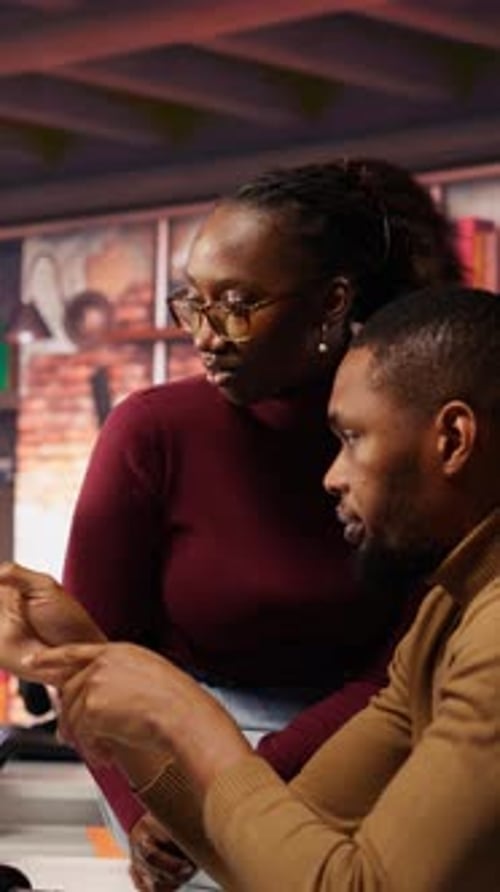 Collaborative Young Adults Discuss Technology in Modern Office