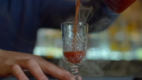 Close Up of Bartender at a Bar Counter Pouring Alcohol Into Vintage Glass Media Pouring Red Hot