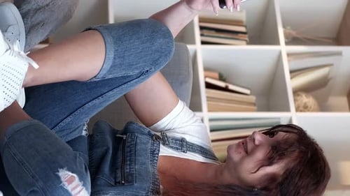 Woman Chatting on Smartphone While Reclining on Couch