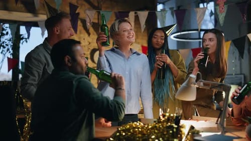 Joyful Team Clinking Beer at Birthday Party in Festive Office Happy Colleagues