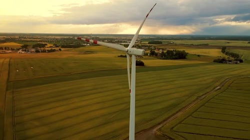 Scenic Aerial View of Wind Turbines Farm in Sunset Time at Evening with Rainy Clouds