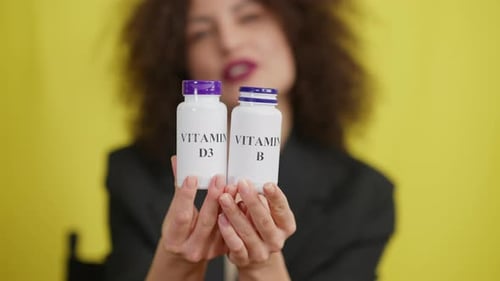 Smiling Woman Presents Vitamin D3 and B Supplements