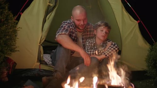 Dad and Son Talking Sitting on Tent By the Fire Family Camping Evening Talk with Kid Like Father