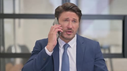 Portrait of Middle Aged Businessman Talking on phone