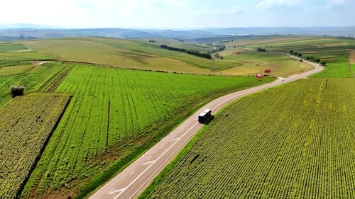 Rural truck driving on scenic roadway. A truck travels along a winding road surrounded