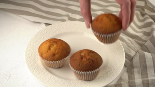 A Woman's Hand Takes and Puts Down the Muffin