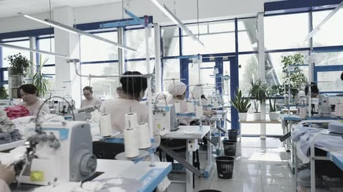 Arbeiter einer Nähfabrik sind damit beschäftigt, Textilprodukte in einer modernen Umgebung herzustellen