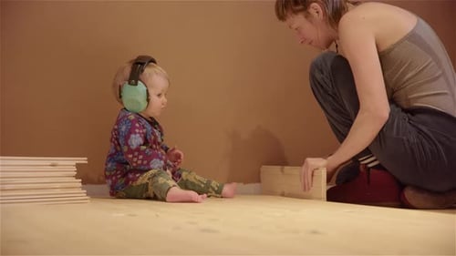 SUPER CUTE of ear defenders being put on baby and mom carrying on building
