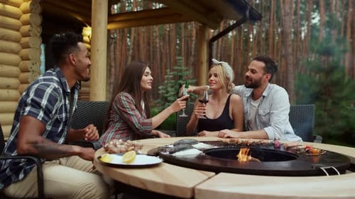 Friends Enjoying Outdoor Grill and Drinks at Cabin