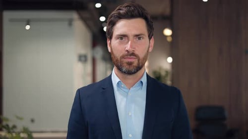 Smiling Caucasian Businessman Looking at Camera While Standing in Modern Office