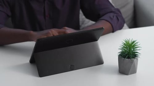 Person Using Tablet at Table Indoors