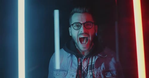Man Yelling in Dark Room with Neon Lights