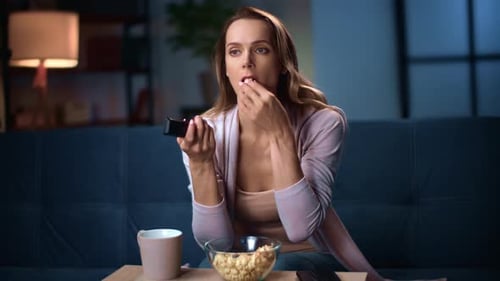 Woman Watching TV at Night with Popcorn