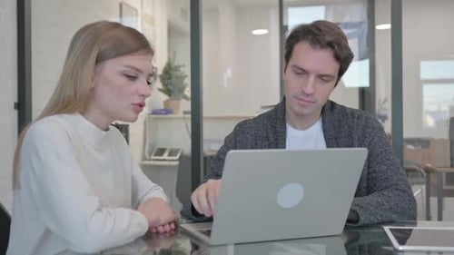 Interracial Couple Working on Computer in Office