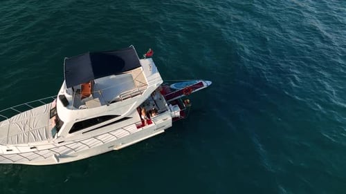 Aerial Drone Tracking Top Down Video of Yacht Cruising in Deep Blue Open Ocean Sea