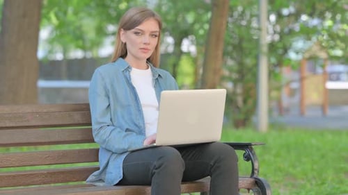 Woman Works on Laptop in City Park