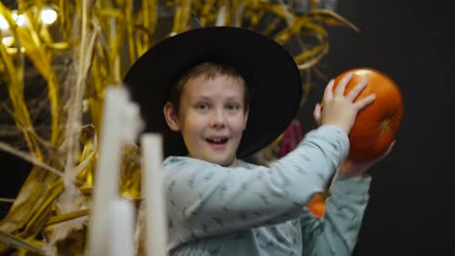 Boy Dressed As Witch Dancing With Pumpkin