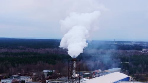 Thick White Smoke Emitting From A Factory Chimney Into The Natural Environment