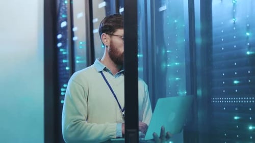 Man Working on Laptop in Data Center