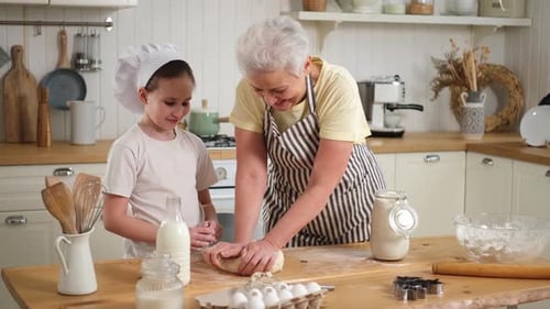 Grandmother and Child Making Dough in Kitchen