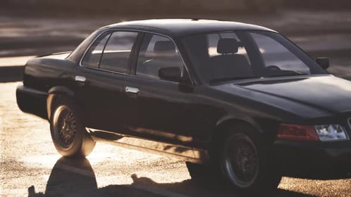 Classic Black Sedan Parked on a Sunlit Street During Golden Hour