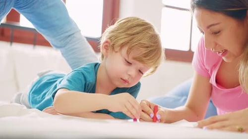 Family Drawing Together on a Bed with Crayons