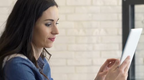 Woman Using Tablet Device Smiling Indoors