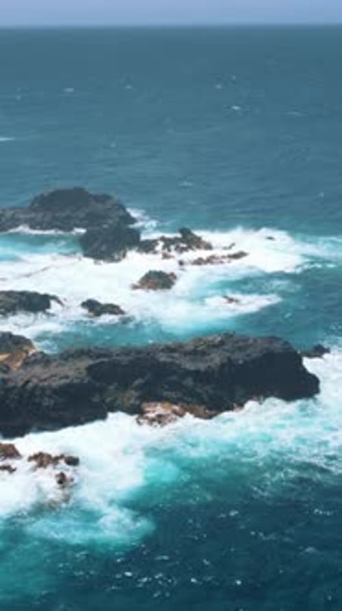 Waves Crashing on Rocks by Tropical Island Coastline