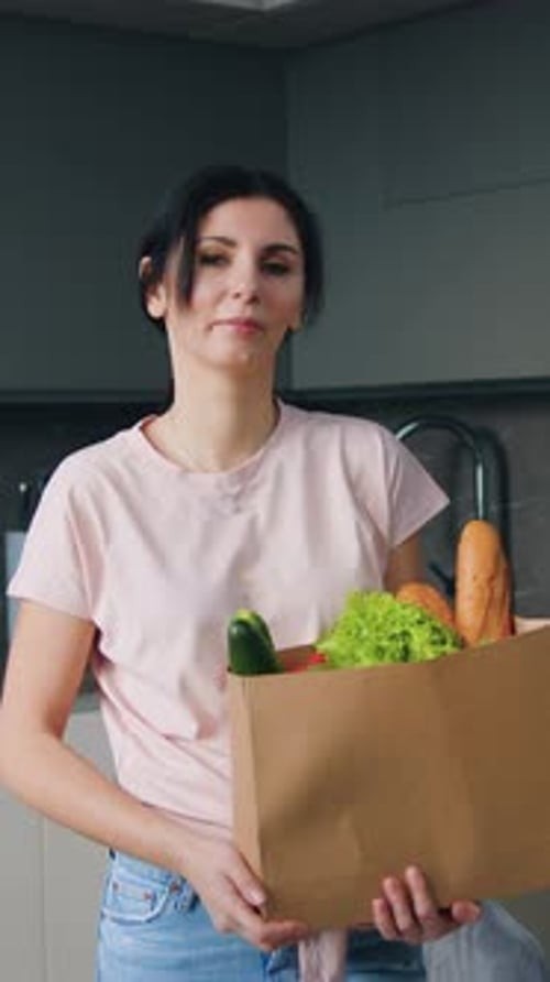 Goodlooking Satisfied Joyful 30Aged Brunette Standing in Beautifully Designeted Cuisine with Paper