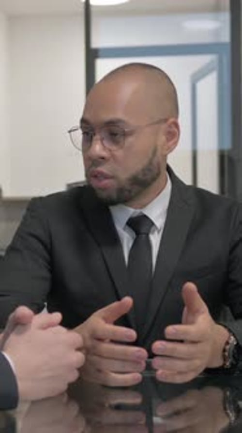 Businessmen Talking in Office Meeting with Serious Expression
