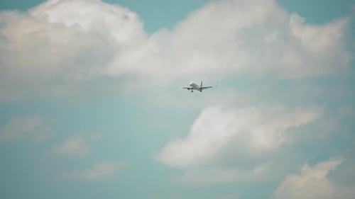 Airplane Descending Through Cloudy Blue Sky