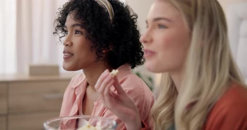 Two Young Women Eating Popcorn Laughing
