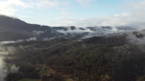 View of the Autumn Forest in the Mountains Through the Clouds