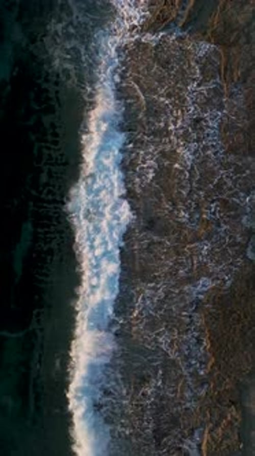 Vertical Video Aerial View of Sunset Rays Reflecting on the Ocean Highlighting the Water s Texture