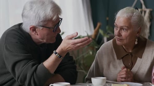 Three Seniors Talk Over Coffee at a Table