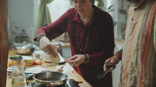 People Cooking Dumplings Together in Sunny Kitchen