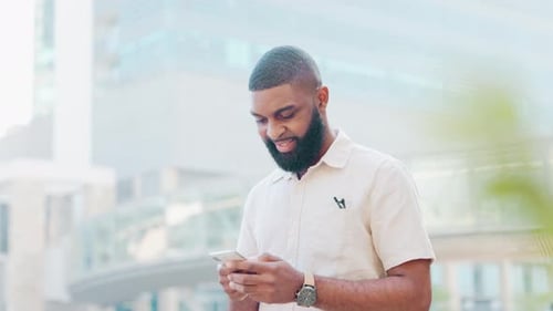 Fashionable man texting on phone, browsing the internet and searching social media in city