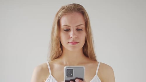 Blonde Woman Using Smartphone in Home