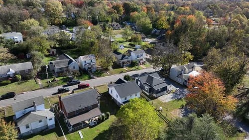 Aerial view of American suburban neighborhood in autumn, with colorful fall trees, quiet streets