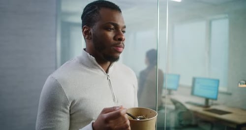 African American Office Worker Eats Food Taking Break During Lunch in Modern Office