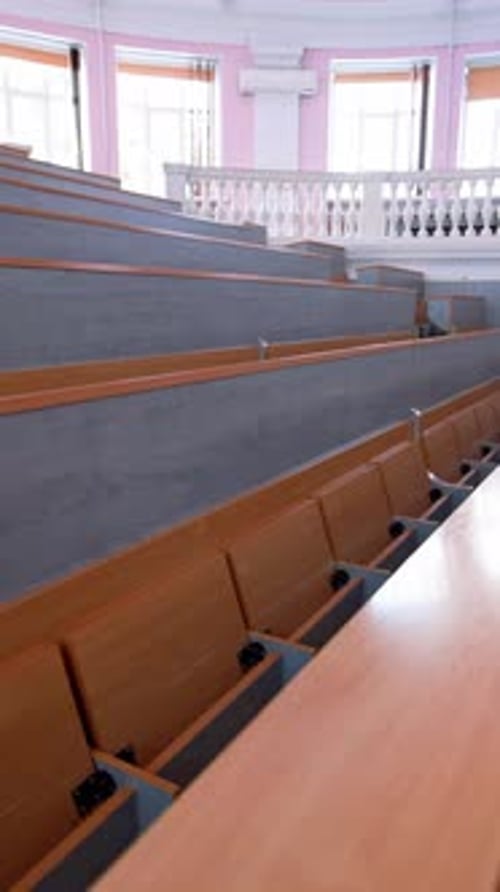 Rows of long desks in conference hall. Empty auditorium in the modern educational center.