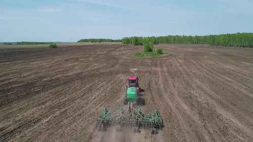 Aerial View of an Agricultural Tractor Performing Plowing Tillage for Sowing Crops A Cultivator