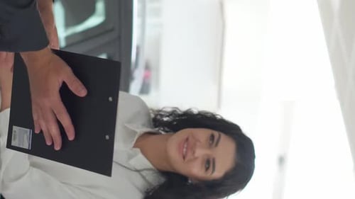 A Young Couple Signs an Order for the Purchase of a Car at the Company's Office Vertical Video