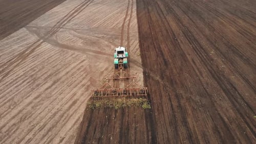 Drone Footage Aerial Drone View of Tractor Plowing on the Field Farmer in Tractor Preparing Land for