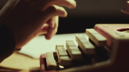 Hands of Writer Working on Vintage Typewriter at Desk