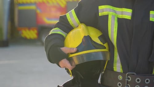 Fireman with Hard Hat in Her Hands Standing at Station Close Up